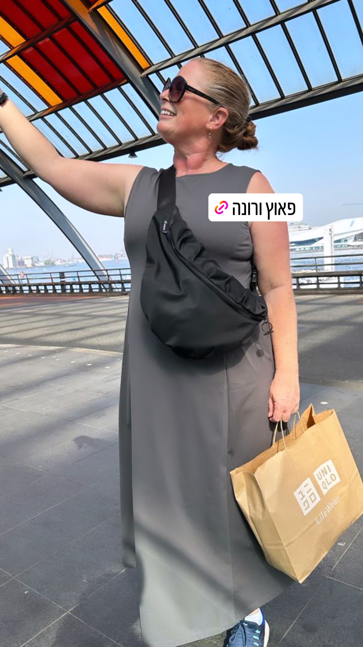 לקוחה עם פאוץ' ורונה גדול שחור בחו"ל – פאוץ' לטיסה בעיצוב עדי בקשי, מבד איטלקי יוקרתי