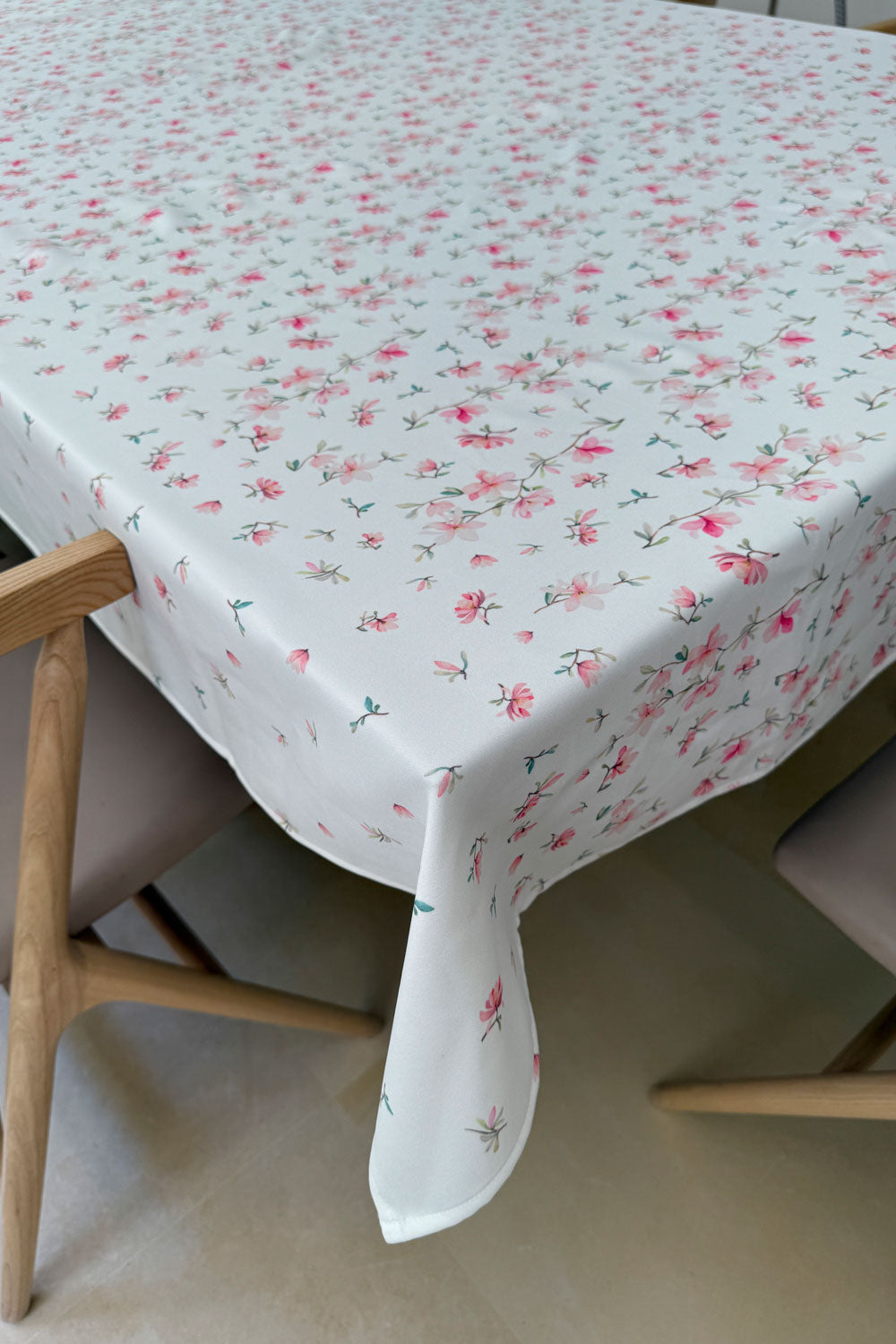 תקריב על בד מפת שולחן גבריאלה עם פרחים ורודים וירוקים מעודנים