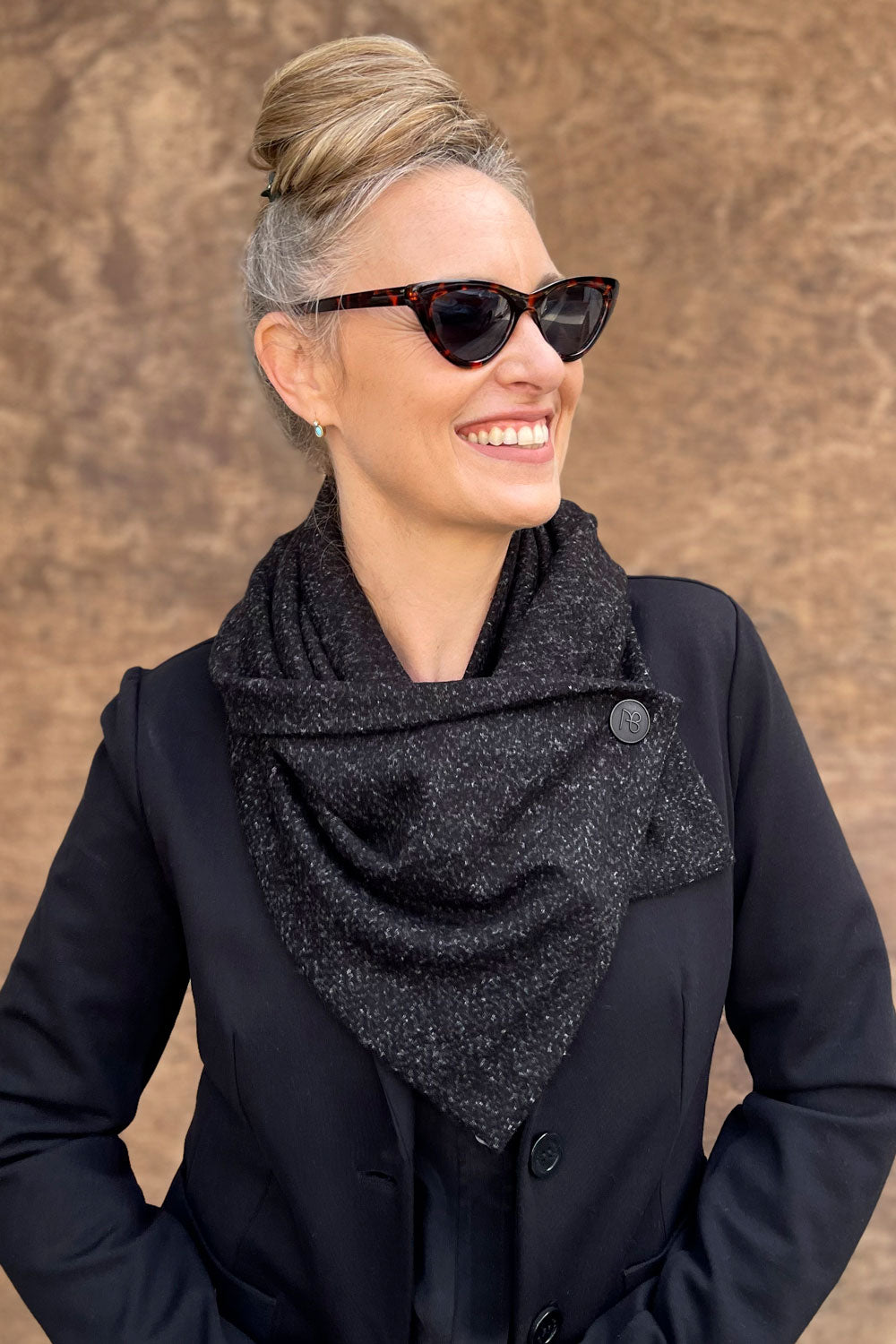 כפתור לוגו איטלקי בגימור שחור־מט על צעיף מלטף טל – עבודת אמייל ידנית